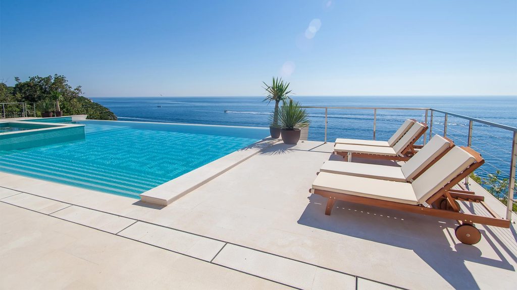 infinity pool with lounge chairs nearby